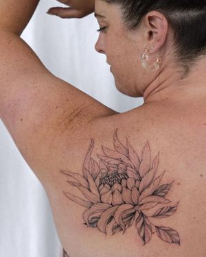 Beautiful blackwork flower tattoo on upper back by Sasha Sunshine, intricate and captivating design.