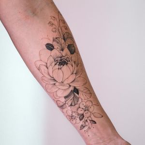 Blackwork flower tattoo on forearm by Sasha Sunshine, featuring detailed illustrative design.