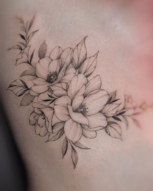 Elegant illustrative flower tattoo on ribs by Irene Bogachuk. Delicate and detailed design.