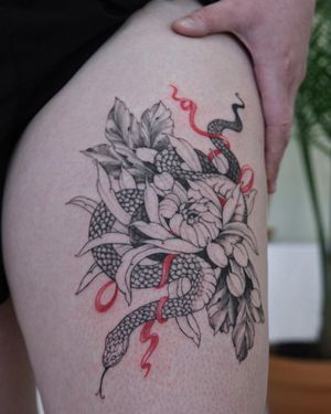Illustrative blackwork tattoo featuring a snake entwined with a flower, beautifully done by Sasha Sunshine.