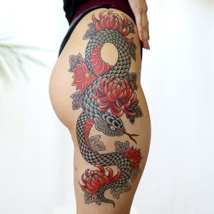 Experience the intricate beauty of Leo Quintao's illustrative style with this stunning upper leg tattoo featuring a fierce snake and delicate chrysanthemum flower motif.