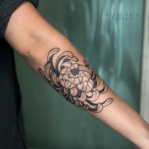 This blackwork tattoo by Stasy Galz features a stunning illustrative chrysanthemum design on the forearm.