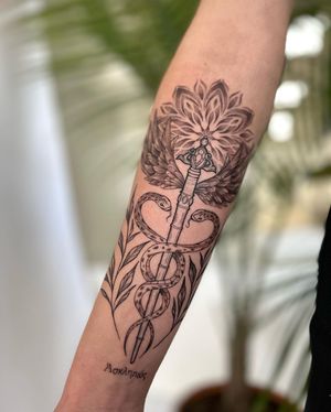 Unique blackwork and dotwork design featuring a snake, sword, and mandala pattern by Stasy Galz. Perfect for a bold and intricate forearm piece.