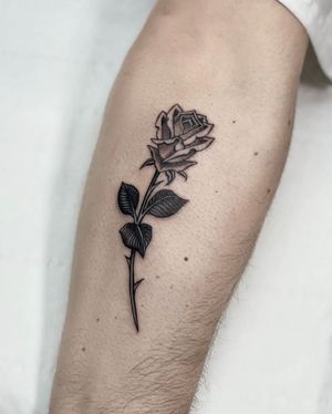 Get a stunning black and gray traditional flower tattoo by Sophie Rose Hunter on your arm to showcase her intricate artistry.