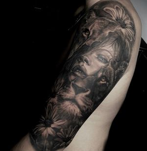 Beautiful black and gray upper arm tattoo featuring a fierce lion and a serene woman, created by the talented artist Nicole Histon.