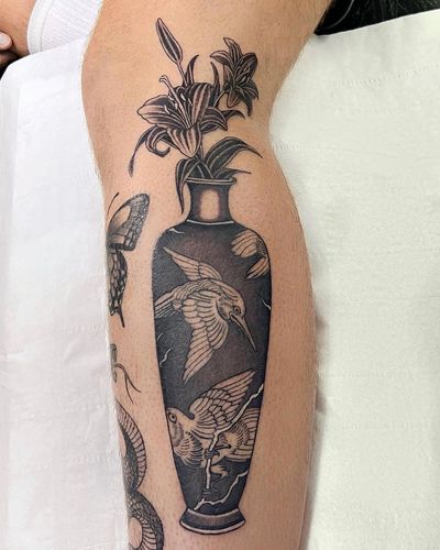 Achieve timeless beauty with a black and gray floral design by Sophie Rose Hunter on your lower leg.