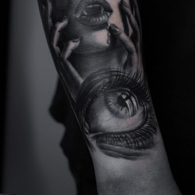 A stunning blackwork forearm tattoo featuring a haunting vampire eye peering through the darkness, intricately designed by artist Nicole Histon.