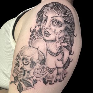 Capture the allure of the femme fatale with this black and gray upper arm tattoo by Letitia Mortimer.