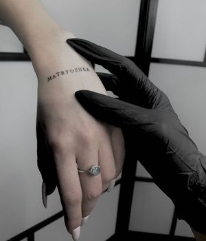 Get a beautifully detailed hand tattoo with fine line small lettering, featuring your favorite quote or name, by the talented artist Nicole Histon.