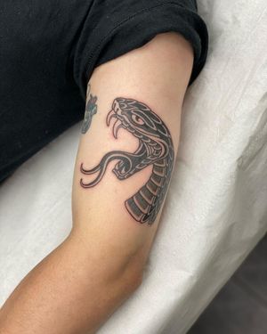 Traditional black and gray snake tattoo on upper arm by artist Sophie Rose Hunter.