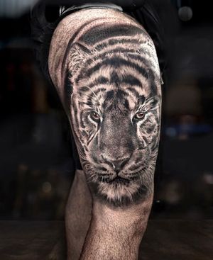 Experience the fierce beauty of a blackwork tiger tattoo on your upper arm by the talented artist Mengni Yang.