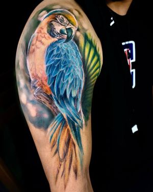 Get a stunning and detailed parrot tattoo on your upper arm by the talented artist Mengni Yang. This illustrative piece will bring vibrant colors and lifelike details to your skin.