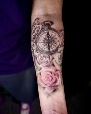 Detailed blackwork tattoo featuring a flower, clock, watch, and filigree design on the forearm. By Mengni Yang.