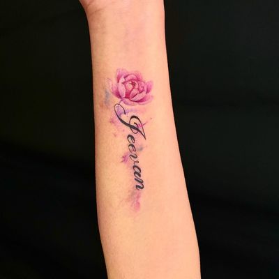 Unique forearm tattoo combining elegant lettering and illustrative flower design. Created by Mengni Yang for a personalized touch.