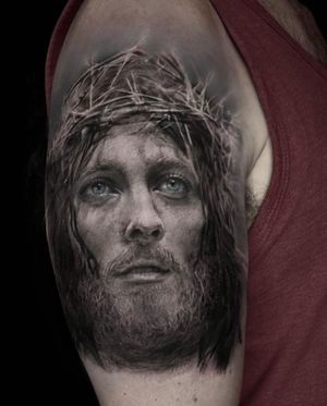Intricate black and gray tattoo on upper arm by Mengni Yang, capturing the essence of Jesus and thorns in a realistic style.