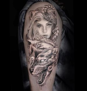 Bold blackwork tattoo featuring a snake, wolf, and woman on upper arm, by Mengni Yang. Perfect blend of strength and grace.