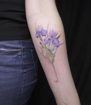 Vibrant and illustrative flower design by Mengni Yang, beautifully placed on the forearm.