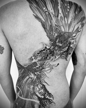 Transform your back into a canvas with this stunning blackwork phoenix tattoo by Tom Cobra.