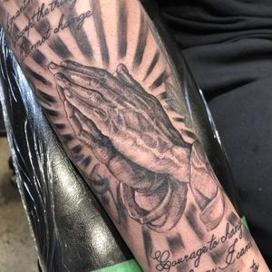 Detailed black and gray forearm tattoo by Pablo, featuring a hand holding a meaningful quote in beautiful lettering style.