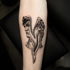 Get a striking blackwork statue tattoo by Oek on your forearm for a bold and unique design.