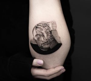 A stunning blackwork illustration of a man wearing a ring, skillfully done by Oek on the forearm.