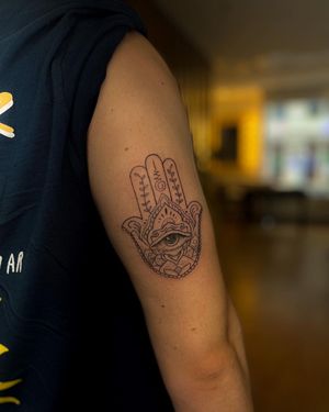 Detailed upper arm tattoo featuring a fine line flower mandala design by Alina Ivenko.