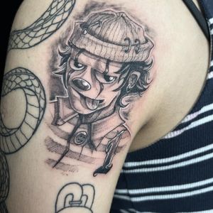 Unique blackwork upper arm tattoo featuring a clown, number, and cap in an illustrative style by Pablo.