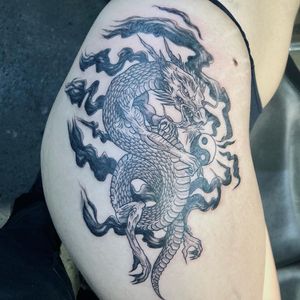 Discover the striking blackwork upper leg tattoo featuring a captivating dragon design, expertly executed by the talented artist Pablo.