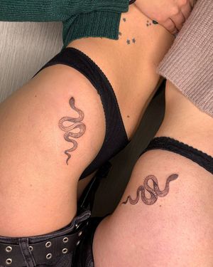 Elegant and detailed snake tattoo by Alina Ivenko, beautifully crafted in a fine line illustrative style on the upper leg.