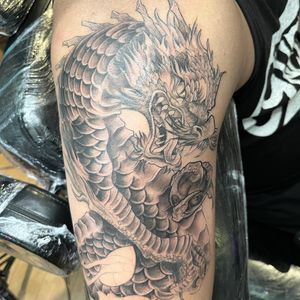 Experience the power and beauty of a Japanese dragon with this illustrative upper arm tattoo by Pablo.