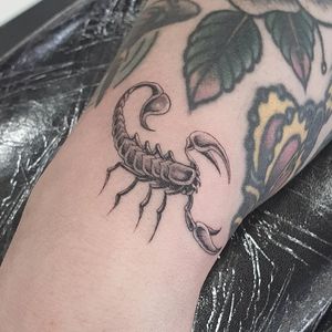 Get a sleek black and gray, fine line scorpion tattoo on your arm in London for a bold and edgy look.