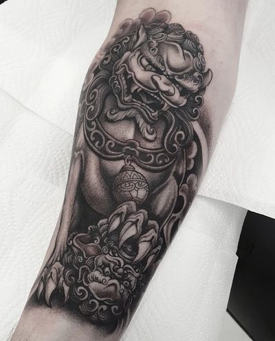 Get a bold blackwork tattoo of a fierce foo dog by Dani Mawby, perfect for your forearm!
