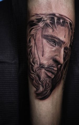 Get mesmerized by Mengni Yang's intricate black and gray illustrative design of Jesus on your arm. Masterfully detailed and lifelike, this tattoo is a true work of art.