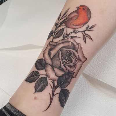 Check out this stunning blackwork tattoo on the lower leg featuring a bird and flower motif, beautifully done by Dani Mawby.