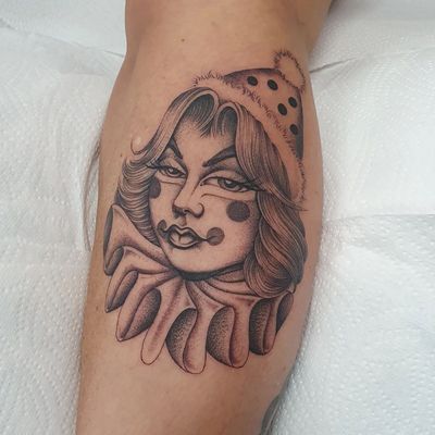 Unique blackwork tattoo on lower leg of a woman wearing a clown hat, by artist Dani Mawby.