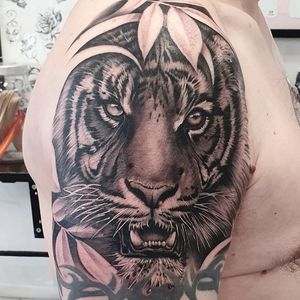Get a fierce and detailed tiger tattoo by Dani Mawby, combining blackwork and illustrative styles. Make a bold statement!