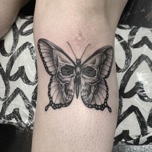 Get a stunning black and gray butterfly and skull tattoo on your knee in London, GB. Book your appointment now!