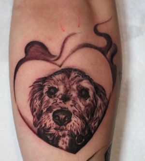 Unique lower leg tattoo featuring a dog and heart design in Carlos Hernandez's signature illustrative blackwork style.
