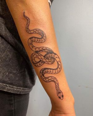 A striking blackwork snake tattoo on the forearm, expertly executed by talented artist Carlos Hernandez.