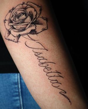 Elegantly detailed blackwork tattoo featuring a flower, name, and quote in fine line and small lettering styles on the forearm. Created by the talented artist Carlos Hernandez.
