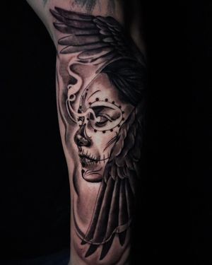 Get inked by Carlos Hernandez with a striking blackwork design featuring an owl, skull, woman, and wings on your forearm.