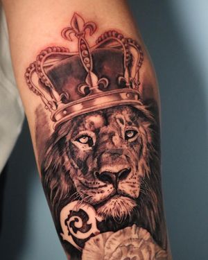 Black and gray masterpiece by artist Carlos Hernandez, showcasing a fierce lion wearing a regal crown.