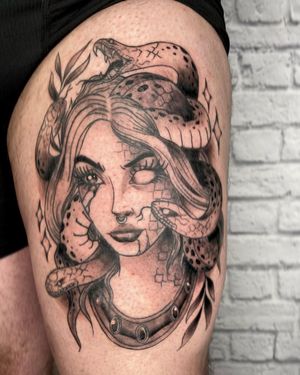 Bold blackwork illustrative tattoo on upper leg featuring a snake piercing a girl by artist Marcos.