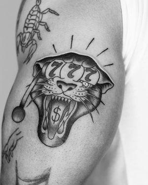 Unique blackwork tattoo by Marcos featuring a fierce tiger, money symbols, and casino number on upper leg.