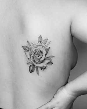 Celebrate a special year with a stunning blackwork flower tattoo on your back, beautifully created by Marcos.