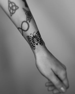 A stunning blackwork butterfly tattoo on the forearm, intricately designed by Marcos. Perfect for a bold and stylish statement.