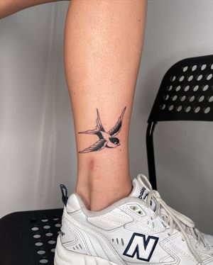 Beautiful illustrative bird tattoo by Sasha, designed for your lower leg with a traditional twist.