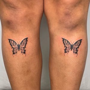 Bold blackwork illustration of a butterfly and moth by Sasha on the shin. Unique and intricate design.