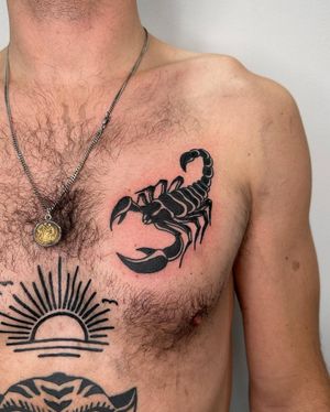 Get a bold blackwork scorpion tattoo on your chest by the talented artist Sasha for a fierce and unique look.