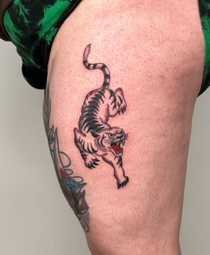 Experience the fierce beauty of a traditional tiger tattoo on your upper leg with Sasha's illustrative style.